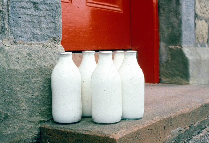 several bottles of milk on a doorstep